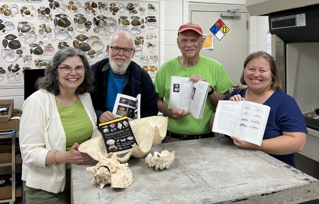 Katie Mosher, Art Bogan, Ed Shuller, and Erika Young hold copies of "Seashells of North Carolina."