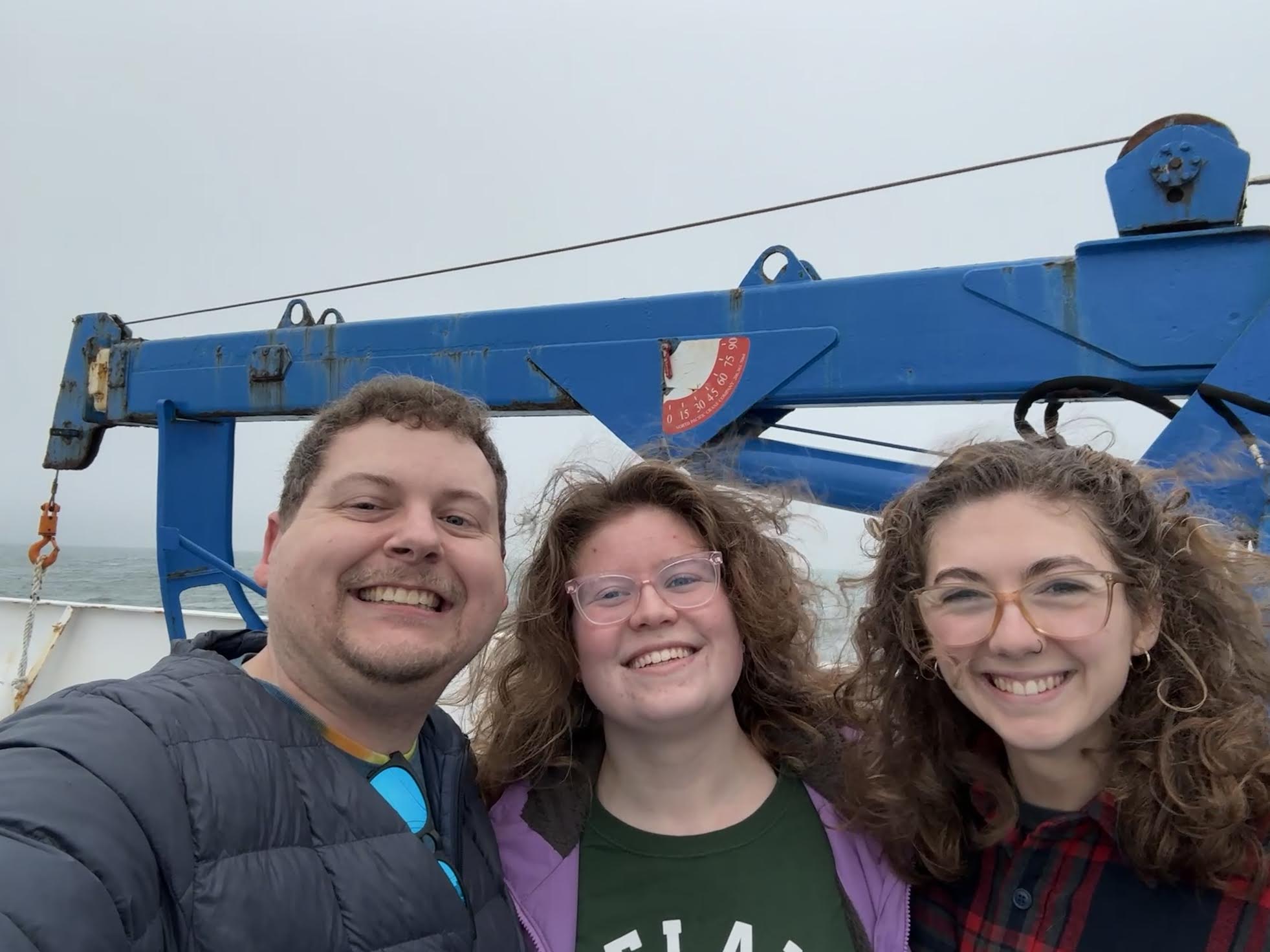 One man and two women on a boat out on the water