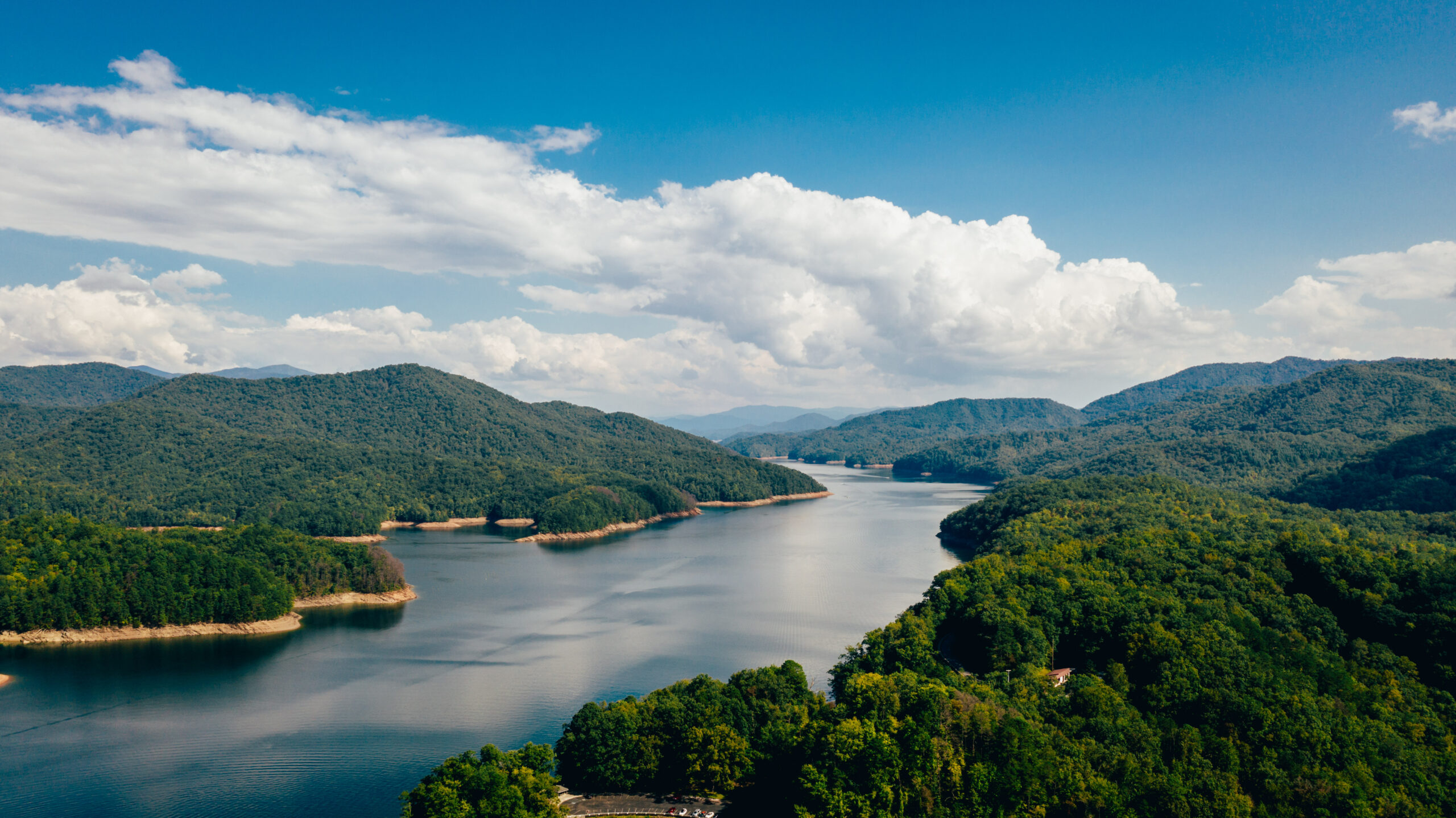Mountains with a river running between them and a blue sky with clouds above